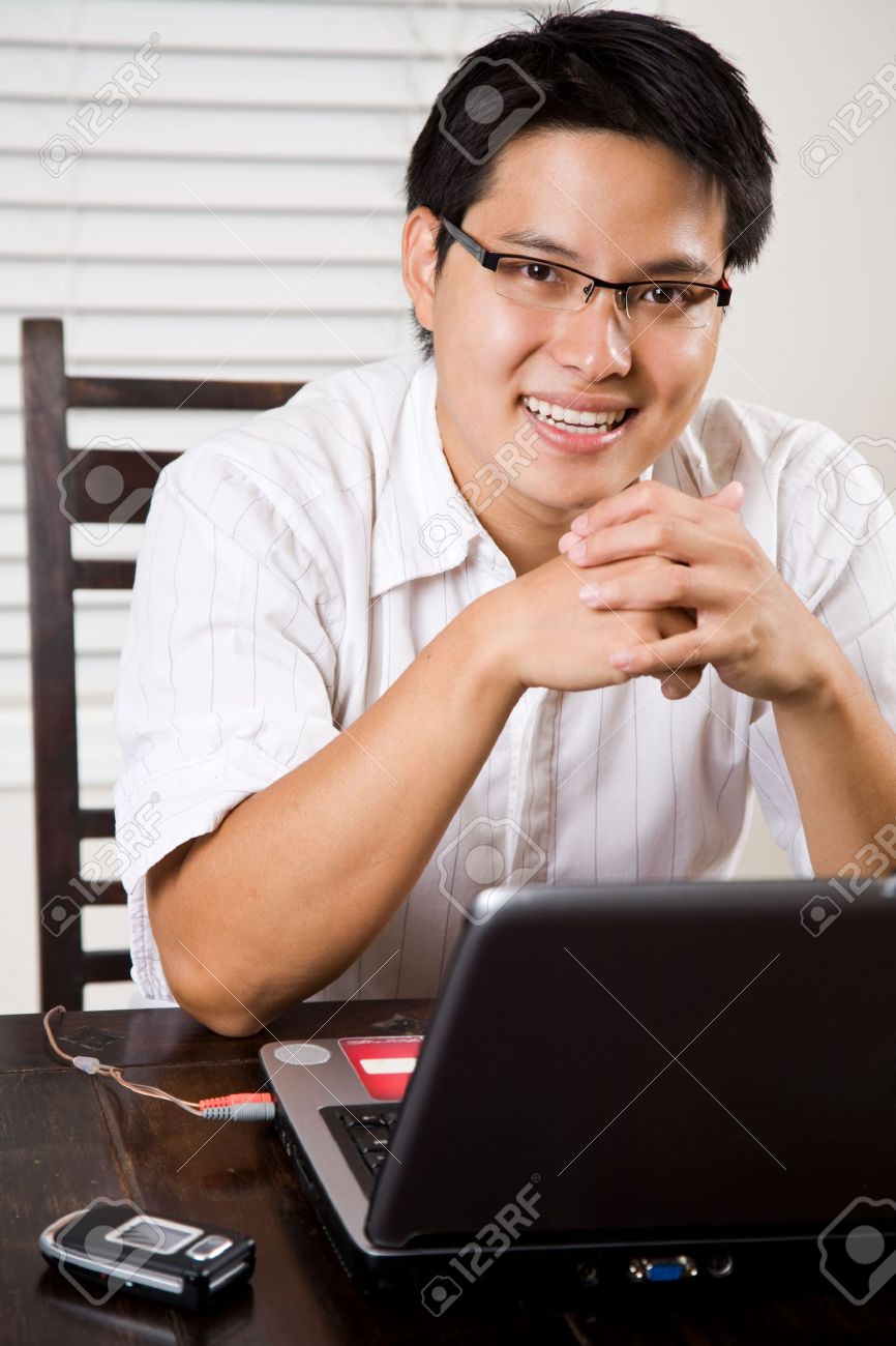 3705527-An-asian-entrepreneur-working-on-his-laptop-from-home-Stock-Photo